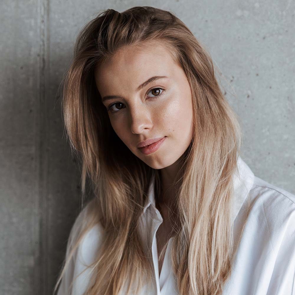 beautiful-young-woman-indoors-over-grey-wall-2J9FTBX.jpg